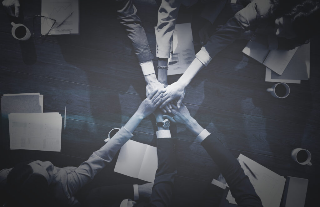 The Power of Partnerships – How Collaboration Drives Competitive Edge business people stacking their hands