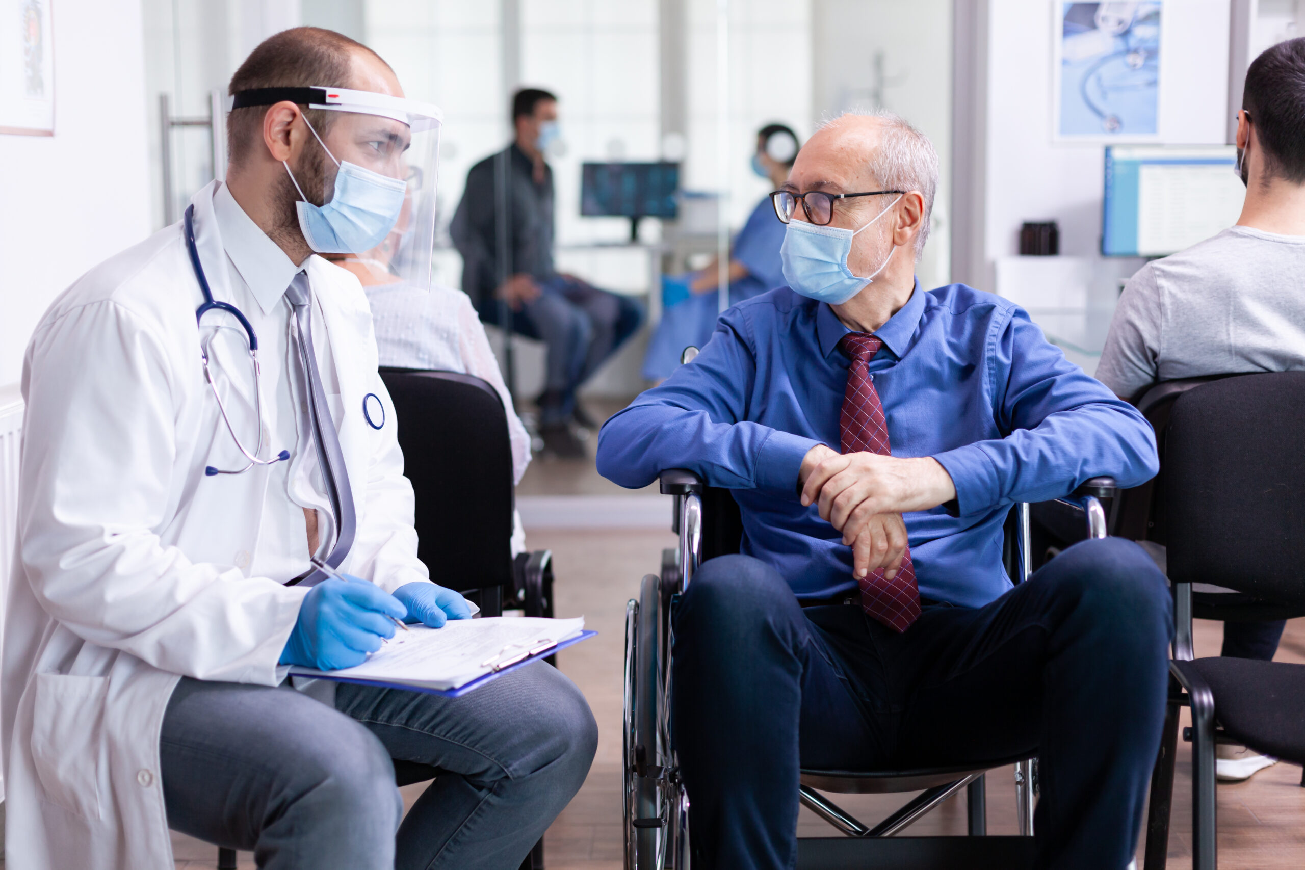 Doctor With Face Mask Stethoscope Consulting Disabled Senior Man Hospital Waiting Area Scaled